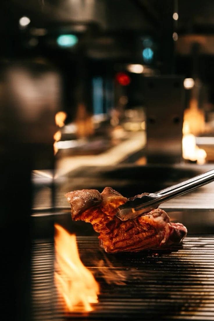 Corte de carne sobre la parrilla a la brasa.
